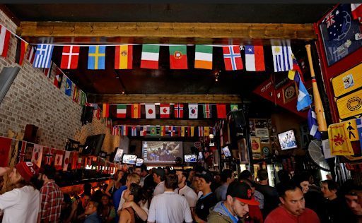 Crowd of soccer fans watching a FIFA World Cup match on large screens inside a packed Toronto sports bar
